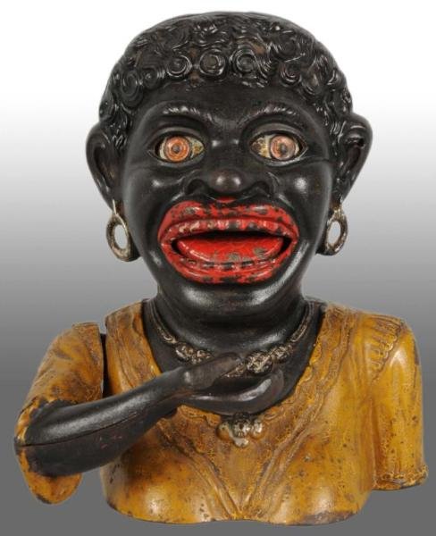 Cast Iron Dinah Mechanical Bank.: Description Manufactured by John Harper and Company Ltd. and registered March 29, 1911. Place a coin in Dinah's hand and press the lever behind her shoulder, she raises her hand, her eyes roll back, a
