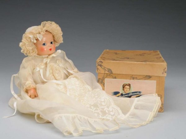 Rare Madame Alexander Composition/Cloth Baby Doll: Description American, circa 1940s. Composition head, lower arms and lower legs, cloth body. Molded brown hair, painted large blue eyes, closed mouth. Tagged Mme Alexander christening gown with lace tr