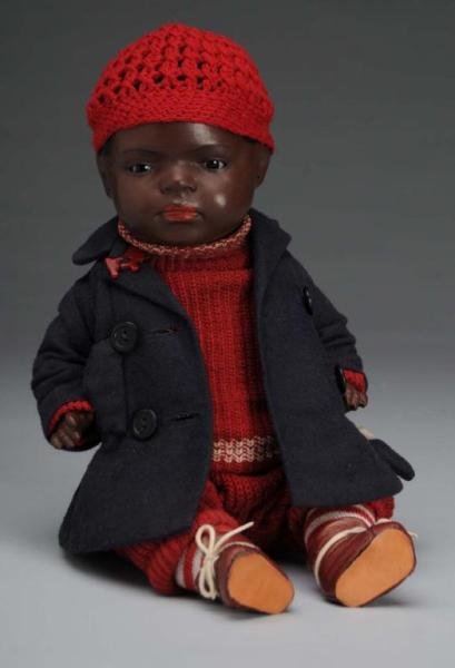Heubach Koppelsdorf Black Baby Doll: Description German, circa 1920. Painted bisque head incised "399". Black painted hair, sleeping eyes, closed mouth, and five-piece composition baby body. Wearing vintage knit sweater and pants, coat a