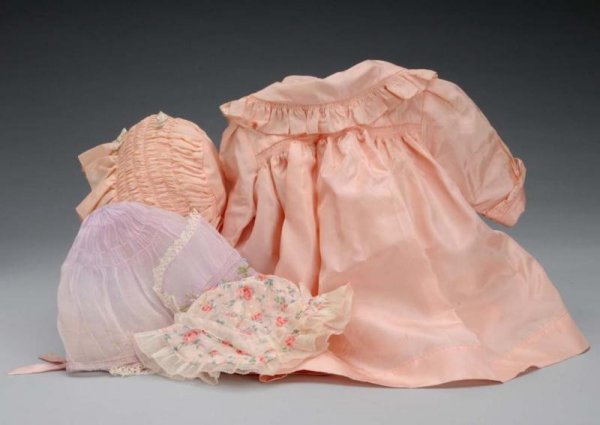 Madame Alexander Baby Doll Coat & Hat.: Description American, circa 1940s. Lovely pink taffeta baby coat tagged Madame Alexander, with matching hat for a large doll. Tiny age holes in coat and light soil. Lavender organdy bonnet for a large