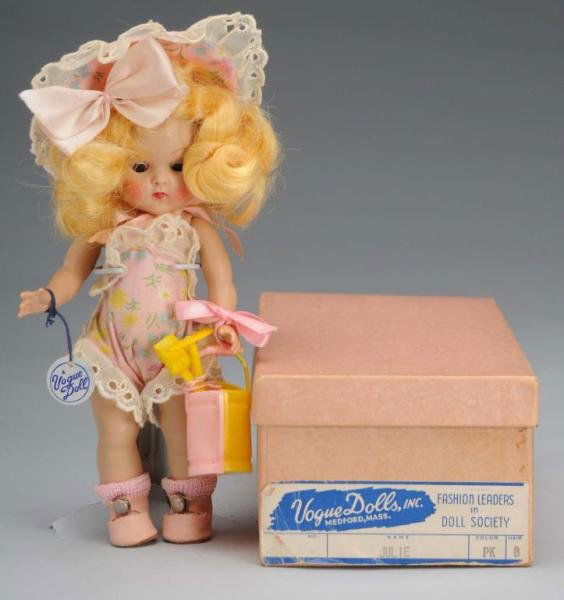 Vogue Hard Plastic Ginny Julie Doll: Description American, circa 1950s. All hard plastic strung doll, blonde mohair wig, brown sleep eyes, rosy cheeks, original pink cotton sun suit with eyelet trim, matching hat, shoes and socks, Vogue