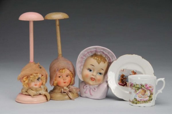 Lot of Misc Children's Items Incl Doll Hat Stands: Description Includes two wooden wig or hat stands with composition doll heads at bottoms. Faces are painted and wearing felt hats. Porcelain head vase of small girl wearing bonnet. Painted face featur