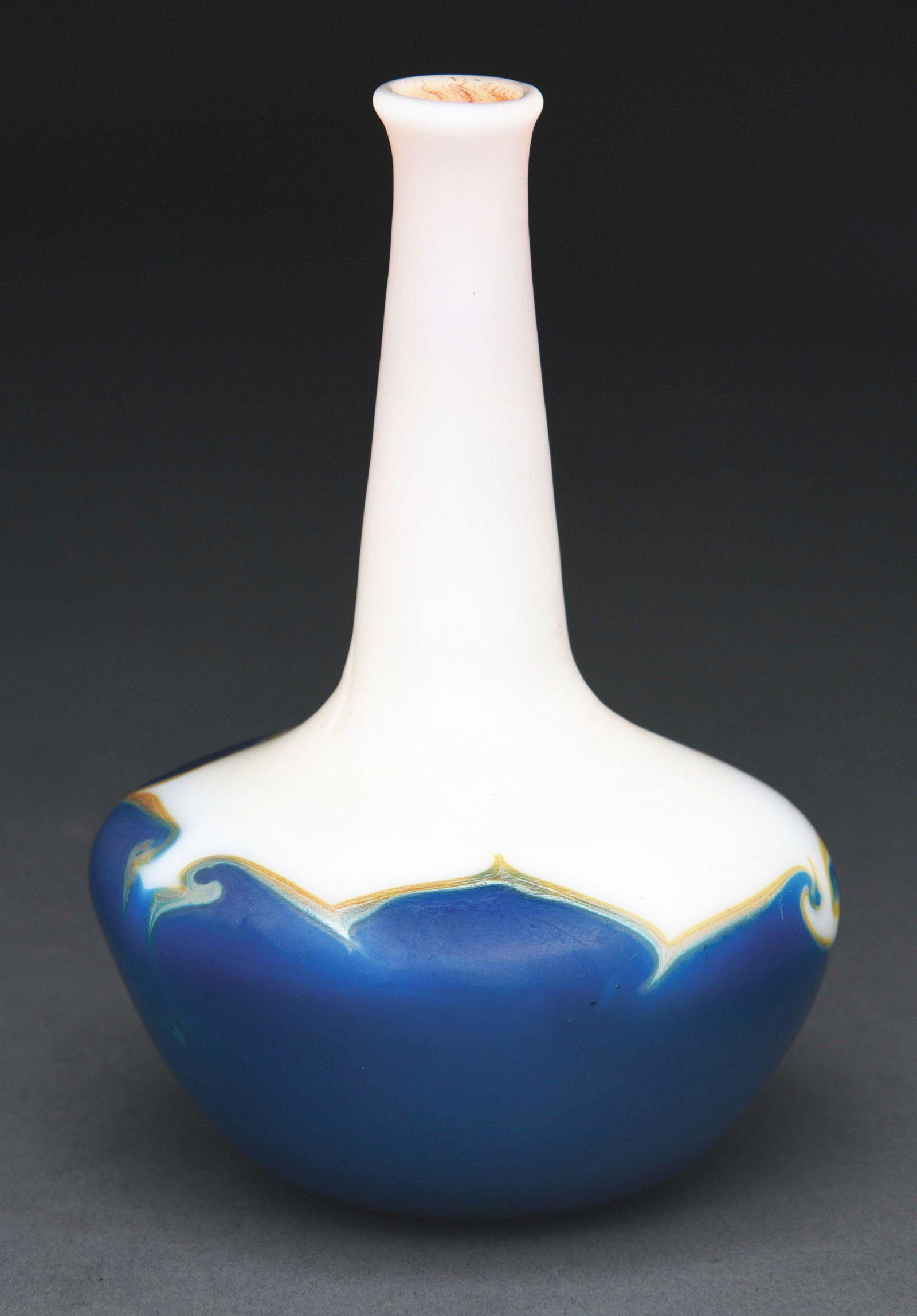 TIFFANY STUDIOS SMALL DECORATED VASE.: A small decorated vase by Tiffany Studios, with bulbous body and long, fluted neck. Neck and top of body are opalescent cream glass, giving way to a rich blue with subtle iridescence. The vase stands 