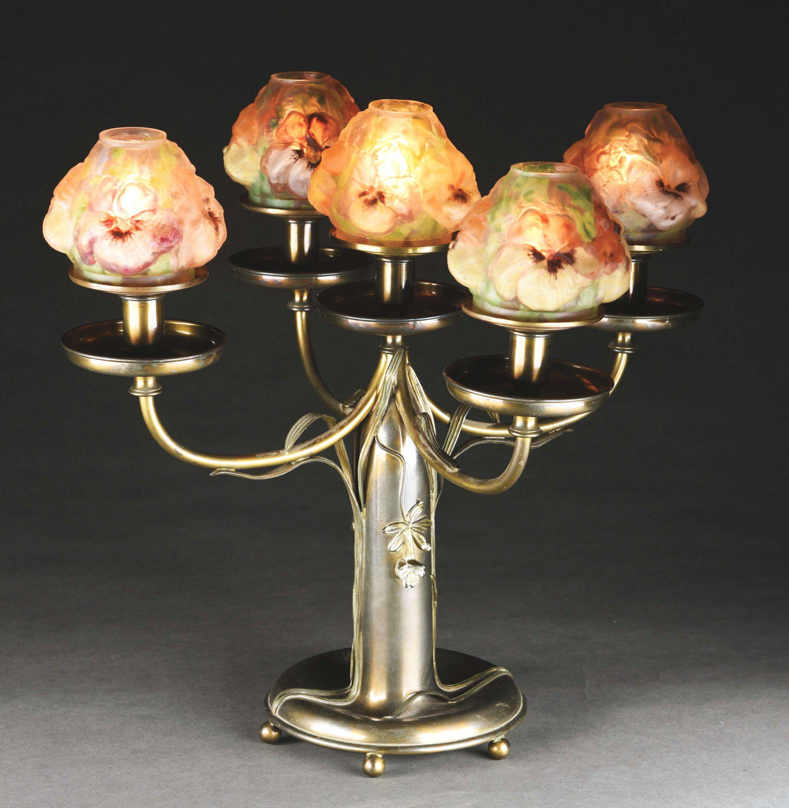 PAIRPOINT CANDELABRA PUFFY TABLE LAMP.: A rare candelabra puffy lamp by Pairpoint. The lamp features five floral shades on an elaborate candelabra base. The shades each have four multi-colored, blown-out flowers, on a frosted background. Th