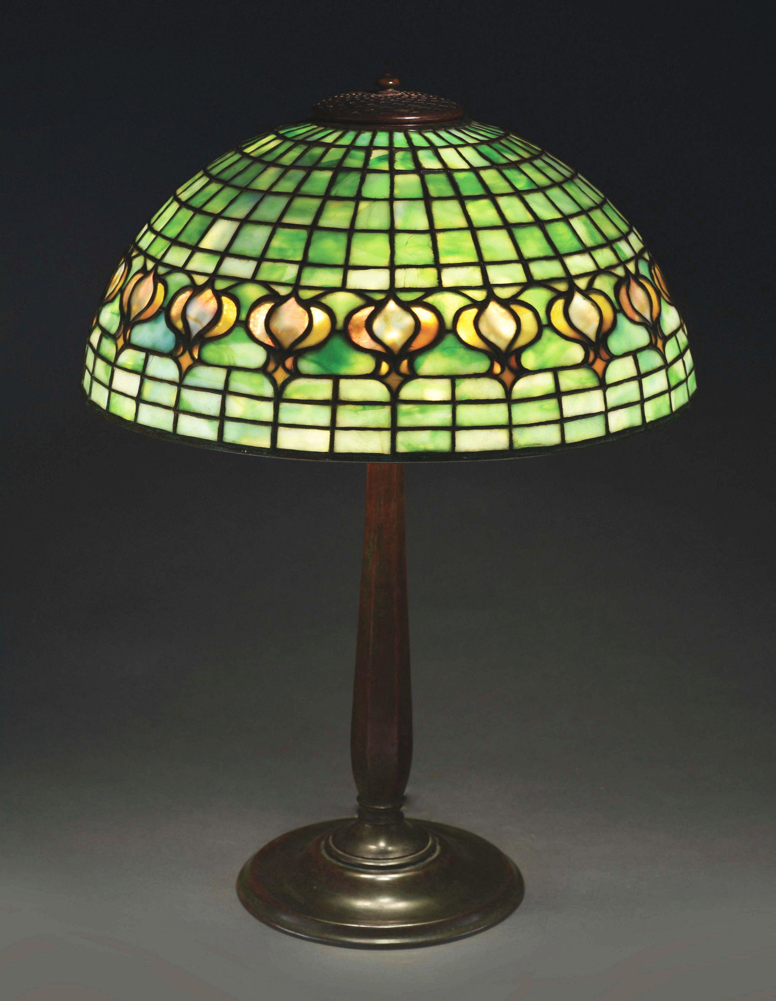TIFFANY STUDIOS POMEGRANATE LEADED GLASS TABLE LAMP.: A leaded glass lamp with pomegranate pattern produced by Tiffany Studios. The 16Â” features a band of pomegranates amidst a geometric background. The pomegranates contain lovely butterscotch and cr