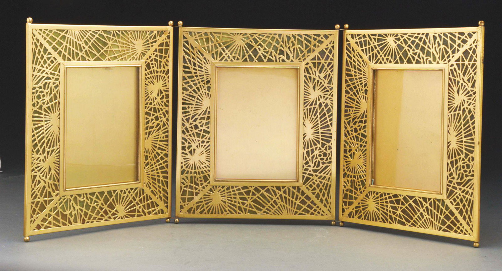 PINE NEEDLE TRIPLE FRAME.: Tiffany Studios gilt bronze and stained glass triple pine needle pattern picture frame decorated in an all-over pine needle pattern with transparent mottled orange-yellow glass with square openings. T