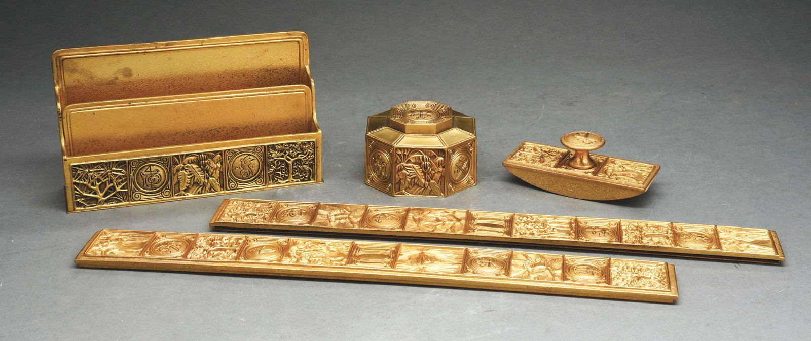 TIFFANY STUDIOS FOUR-PIECE DESK SET.: A beautiful Tiffany Studios four-piece desk set in the bookmark pattern. The set is finished in a brilliant gold dore. The set includes and inkwell with glass insert (#864), letter holder (#1020). Roc