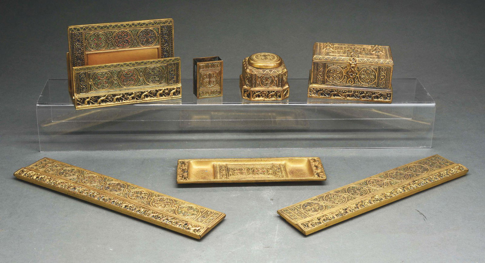 TIFFANY STUDIOS SIX-PIECE VENETIAN DESK SET.: A 6 piece desk set in the Venetian pattern in gold dore, with the following pieces: double Inkwell with no inserts (1641), single inkwell with glass insert (1700), pen tray (2012), matchbook holder (n