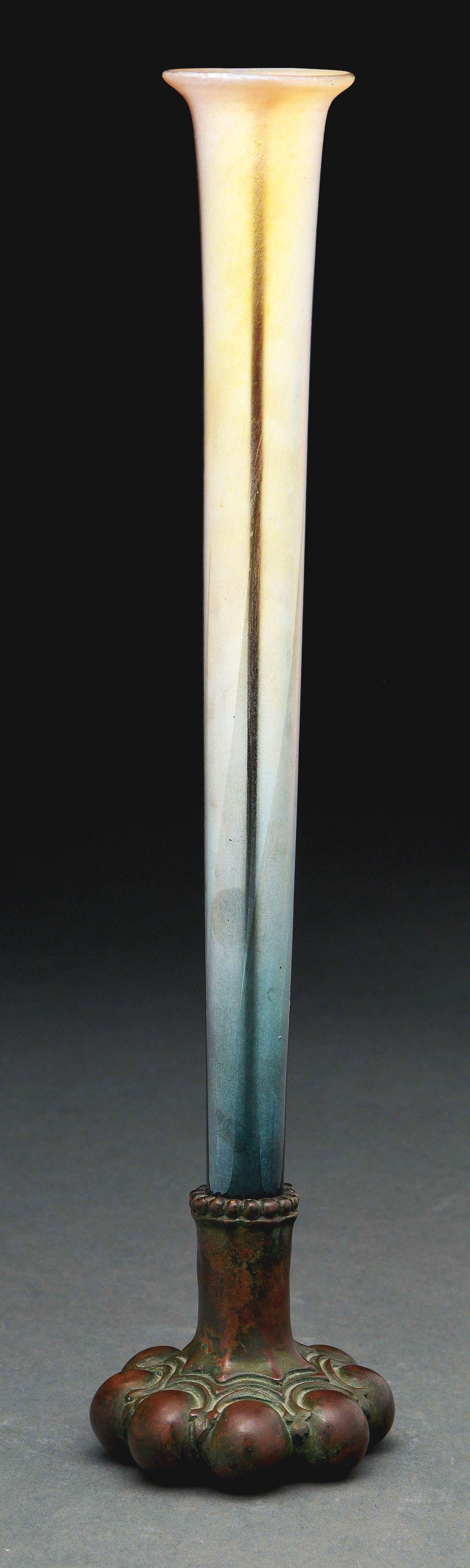 TIFFANY STUDIOS FAVRILE VASE WITH PATINATED BRONZE: A beautiful Tiffany Studios Favrile glass vase having a trumpet form, with gold iridescent glass towards the top, which progresses to a deep green towards the bottom. The glass inserts into a patinate
