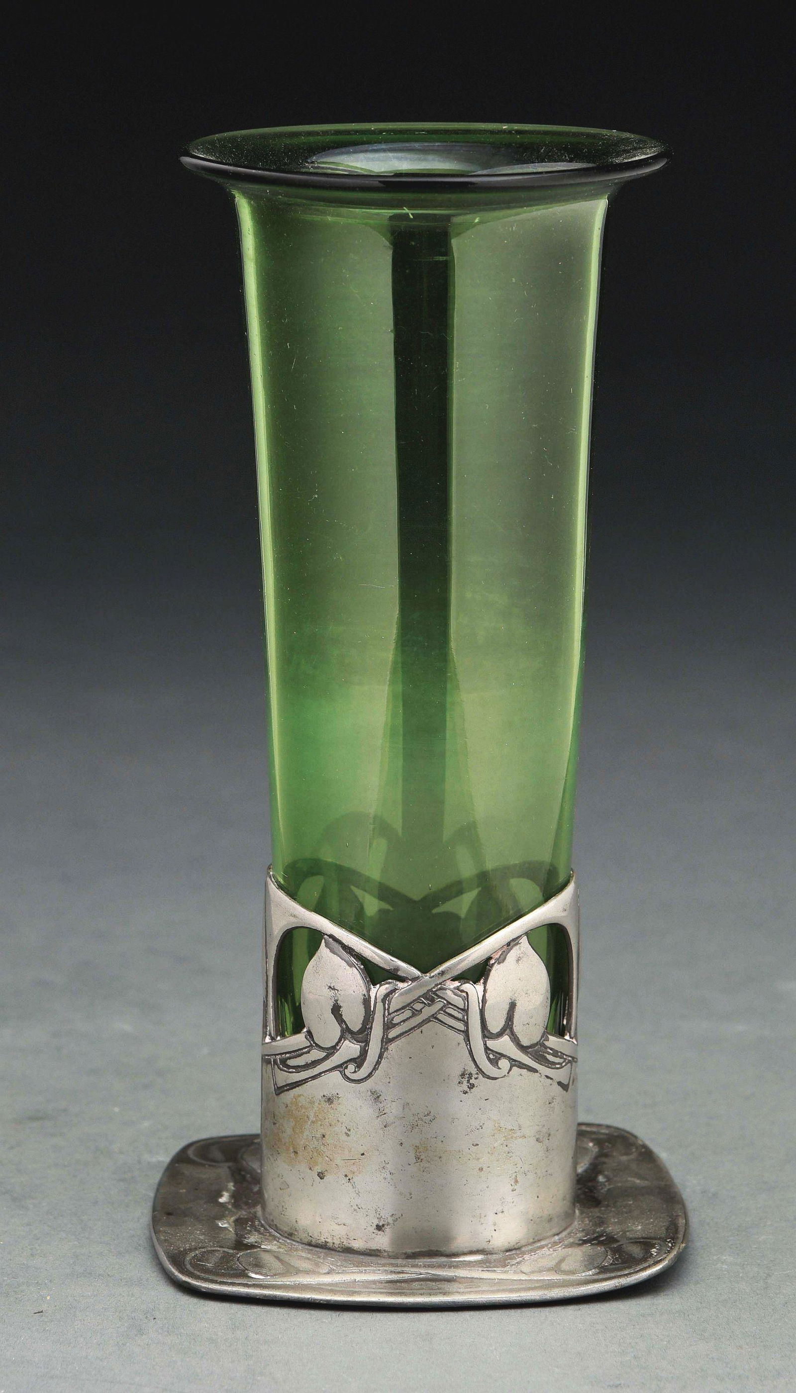 LIBERTY TUDRIC PEWTER AND GLASS VASE, KNOX DESIGN.: This Liberty Tudric pewter vase with green glass insert is an Archibald Knox design. Pleasing pierced and raised vine design on the pewter base. Impressed "Tudric 2324" along with a registration numbe