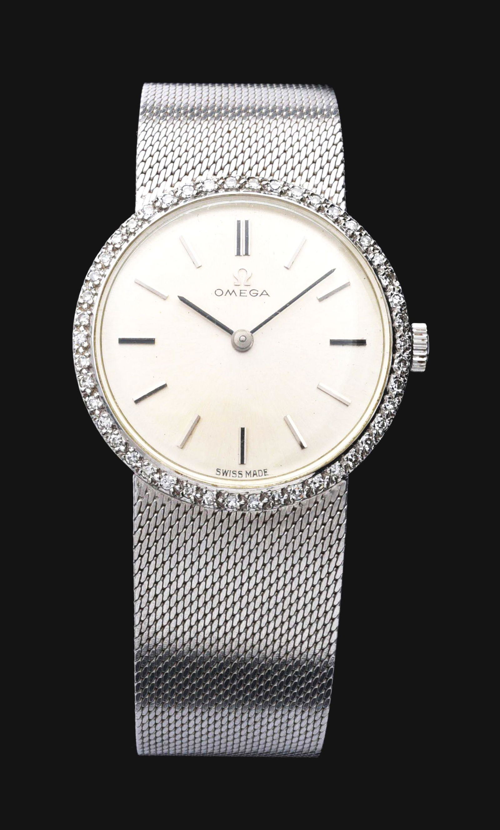 14K WHITE GOLD OMEGA DIAMOND WRIST WATCH, CIRCA 1964.: 14K white gold Omega wristwatch with diamond bezel, Ref. D6690. Case measures 28mm in diameter w/o crown. Matte silver dial with silver stick markers. Original Omega logo crown and buckle. Marked "14K