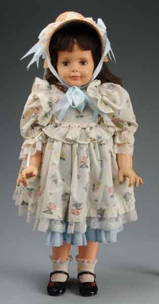Large Ideal Vinyl Doll.: Description Sleep eyes, rooted dark hair, and jointed at shoulders and hips. Doll is wearing Mary Janes with blue dress and lace trim, floral print pinafore, and oversized straw hat. Condition (Very G
