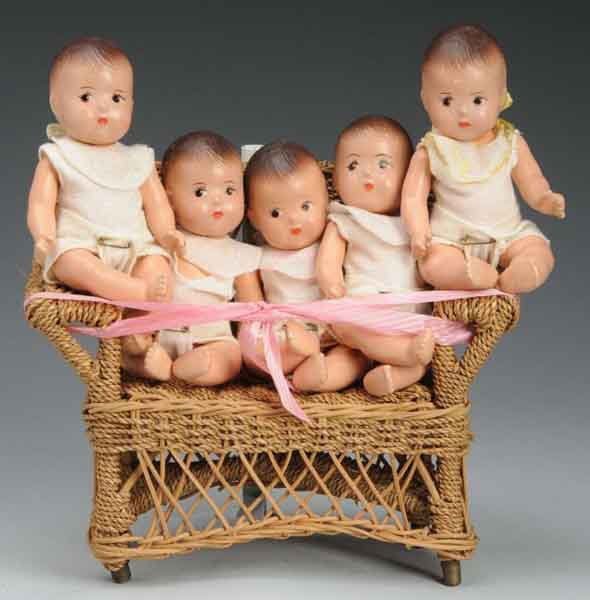 Set of Madame Alexander Dionne Quintuplets.: Description Includes five all composition babies with swivel necks, original knit underclothing, and bibs bearing their name. Babies are sitting in a wicker chair. One doll is missing one arm. Conditi