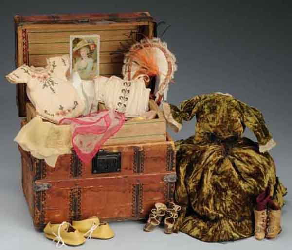 Wooden Lithographed Trunk of Doll's Clothing.: Description Trunk has hinged top with removable two-part tray. Contains an assortment of scarves, corsets, a pair of pink cloth antique doll shoes, and a pair of leather fashion doll boots with heels.