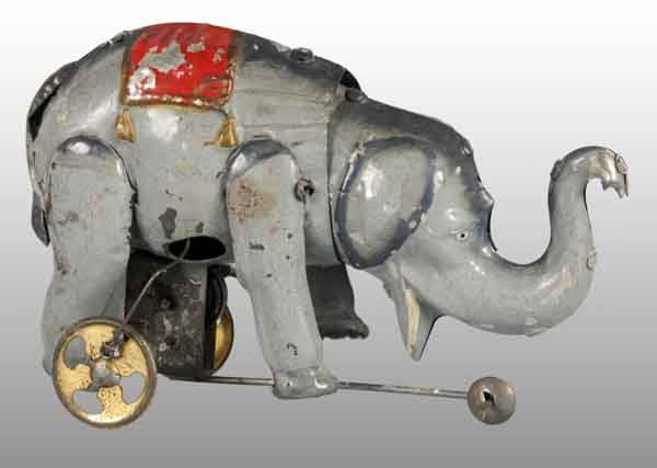 Tin Hand-Painted Elephant Wind-Up Toy.: Description German. Working. When wound, elephant walks forward and head nods up and down. Includes three wheels under mechanism as well as a guiding wheel. Very nicely painted toy with red blanket an