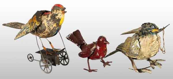 Lot of 3: Tin Hand-Painted Bird Wind-Up Toys.: Description German. Largest toy is on a three-wheel platform with flapping wings. Lot also includes two toys with movable wings but do not flap when mechanism is wound. Moderate overall paint loss, es