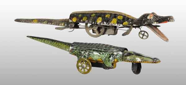 Lot of 2: Tin Alligator Wind-Up Toys.: Description German. Includes one tin lithographed toy and one hand-painted tin toy. Both are marked "Made in Germany" on the bottom and roll on wheels. When wound, arms, tails, and legs move on hand-p