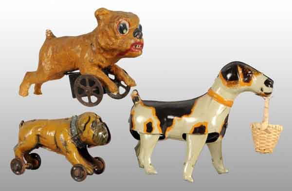 Lot of 3: Tin & Composition Dog Toys.: Description German. Working. Includes one tin nickel-sized bull dog push toy with wheels, one tin wind-up walking dog carrying basket, and one wind-up composition dog that moves forward with wheels on
