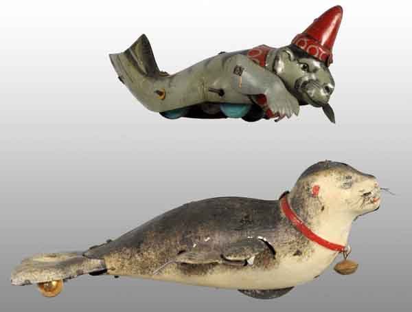 Lot of 2: Tin Seal Wind-Up Toys.: Description German. Working. Includes lithographed seal wearing hat with movable arms marked "Made in Germany" along with Lehmann seal with original bell and whiskers. Both have very little wear. Cond