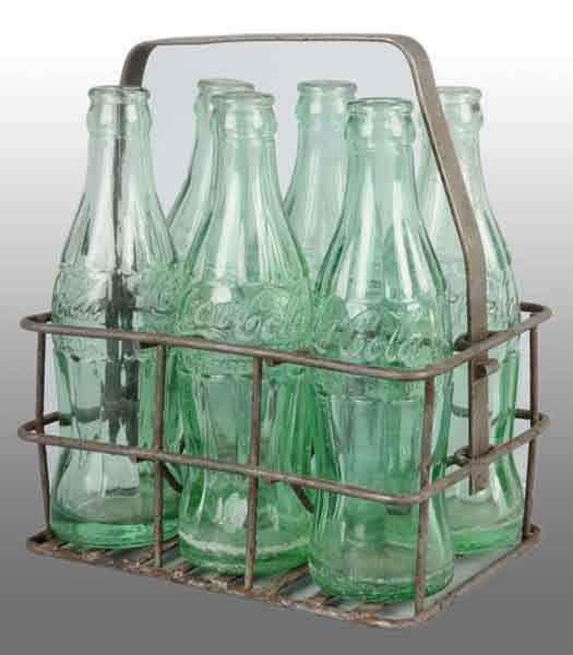 Heavy Iron Coca-Cola 6-Pack Carrier.: Description Circa 1930s to 1940s. Manufactured by Oklahoma Bottling Company. Includes six, six-ounce bottles. Moderate overall wear. Condition (8.0, Excellent). Size 8".
