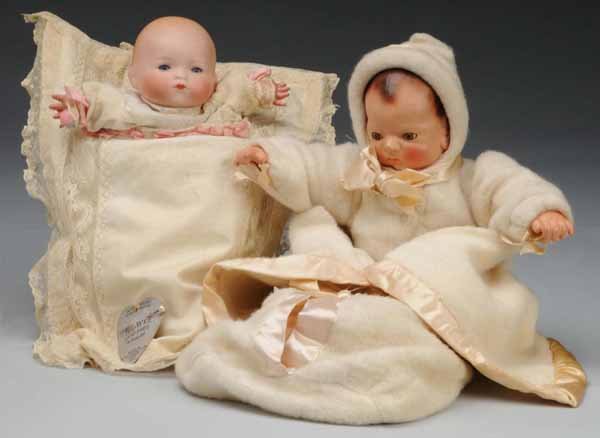Lot of 2: Baby Dolls.: Description Effanbee Babyette with composition head and hands, (lumpy spot over one eye, mold flaw or repair), inset eyes, rosy cheeks, pouty mouth, cloth body, composition hands, original bunting, ja