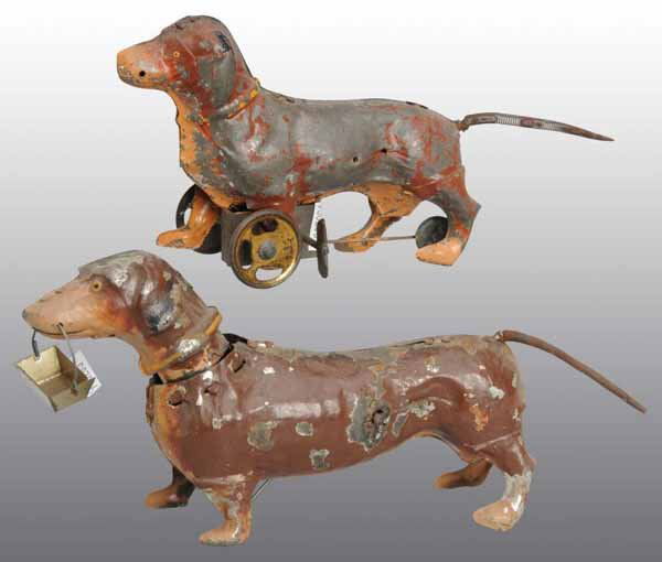 Lot of 2: Tin Hand-Painted Dachshund Dog Toys.: Description German. Working. Larger toy is carrying a tin basket while the smaller toy is on wheels. Both have original spring tails with moderate overall paint loss and wear. Condition (Very Good). S