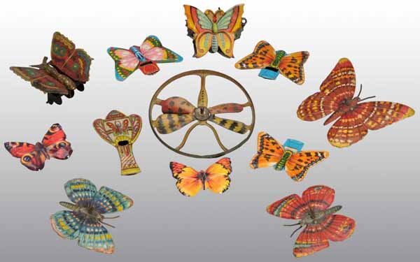 Lot of 12: Tin Litho Butterfly Toys.: Description German and Japanese. Beautiful lithography. Includes a set of three Marklin butterflies with spinner and plunger. Also includes four Japanese whistles and other various penny-sized toys. C