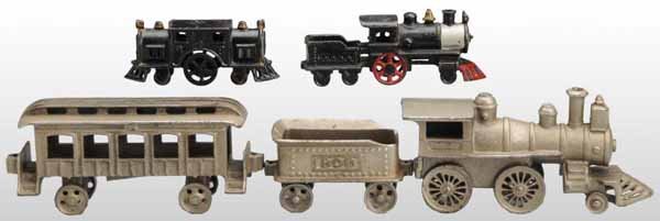 Lot of Cast Iron Toy Trains.: Description American. Includes a three-piece Arcade set consisting of an engine, tender, and pullman car. Also includes an A.C. Williams engine and tender along with an electric-type engine. Some mode