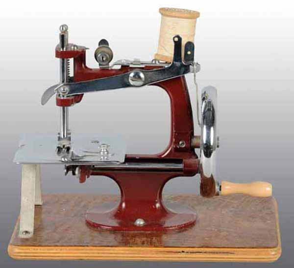 Lot of 2: Child's Toy Sewing Machines.: One marked as English. Both metal and mounted on boards. Light wear. Lot also includes an Essex Miniature Sewing Machine pamphlet. Each: 8" x 7".