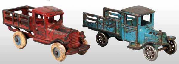 Lot of 2: Cast Iron Arcade Stake-Back Truck Toys.: Includes one with white rubber tires and blue hubs and one with nickel wheels and a partial Arcade sticker on driver's side door. Both have moderate overall paint loss and wear and the nickel wheels a