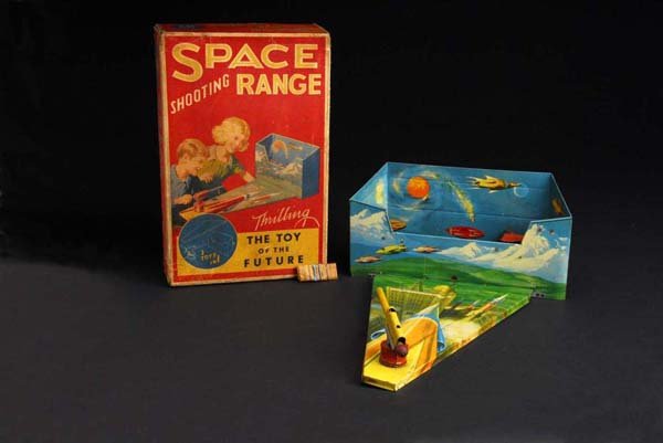 Space Shooting Range Toy.: Description American. Made by Automatic Toy Company. Working. When game is wound, spaceships rotates as they're fired upon by gun from other end of base. Includes original box missing inner flaps and