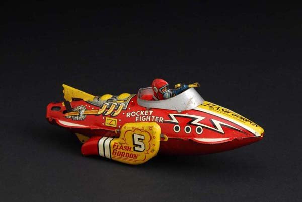 Tin Flash Gordon Rocket Fighter Wind-Up Toy.: Description American. Working. Marked "Flash Gordon 5" on both side fins. When wound, toy sparks. Original tail fin. Moderate overall scratching and wear with some oxidation to front silver windshield