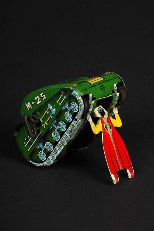 Tin Linemar Superman Tank Wind-Up Toy.: Description Japanese. Working. Marked "M-25" on both sides of tank. Superman figure on bottom of tank raises toy when wound. On/off switch is missing with moderate overall scratching and wear. Conditi