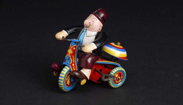 Tin Linemar Wimpy Cyclist Wind-Up Toy.: Description Japanese. Arms and legs are celluloid. Working sporadically. Marked "King Features Syndicate" on rear of toy. Arms have been replaced. Size 4" T.