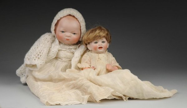 Lot of 2: Bisque Babies.: Description Germany, Ca. 1910-1920. Bisque head Bye-Lo Baby incised Grace S. Putnam, sleeping eyes, closed mouth, signed cloth Bye-Lo body, perfect celluloid hands, vintage clothing. Bisque socket hea