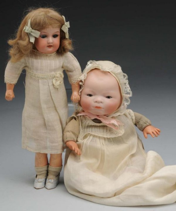 Lot of 2: Bisque Dolls.: Description German, Ca. 1923 and 1900. Bye-Lo Baby, bisque head fully marked Copr. By Grace S. Putnam, sleeping eyes, closed mouth, original cloth body with perfect celluloid hands and "frog" legs, vi