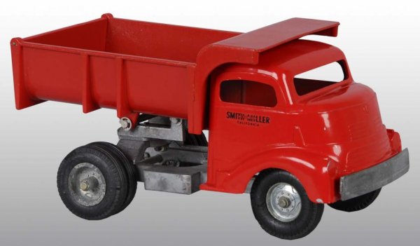 Pressed Steel Smith-Miller Dump Truck Toy.: Description American. Unusual orange-like color with black decals on sides of cab read "Smith-Miller Smitty Toys California". Very little paint wear and some oxidation to back hubcaps. Old store stock