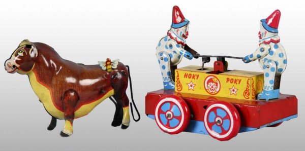 Lot of 2: Tin Character Wind-Up Toys.: Description American. Both are working. Includes Ferdinand the Bull with original butterfly and Hokey Pokey Car. Both have moderate wear with some spots of corrosion on Hokey Pokey base. Ferdinand toy