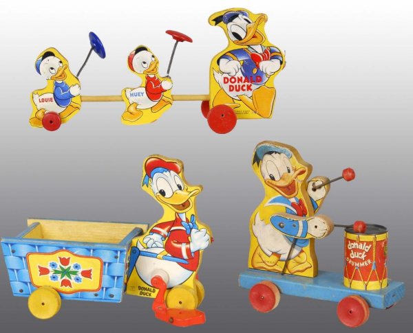 Lot of 3: Fisher Price Donald Duck Pull Toys.: Description American. Includes one Donald Duck Drummer, one Donald Duck pulling cart, and one Donald Duck pulling nephews Huey and Louie. Condition (Very Good). Size Largest: 12" L.