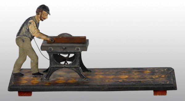 Tin Steam Accessory Work Toy.: Description German. Unusual. Depicts a man sawing a piece of wood in half. Some paint loss throughout. Condition (Very Good). Size Base: 12" L. Toy: 5" T.