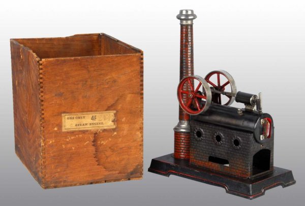J. Falk Overtype Steam Engine Toy.: Description Includes original wood box. Double flywheels, single cylinder, whistle, waterglass and a very pleasing imitation brick smokebox and chimney. Paint loss to the boiler stand. Condition (Very