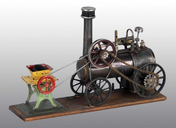 Rare Bing Live Steam Traction Engine w/Accessory: Description Bing traction engine set up to operate a grinder. Mounted on a wood board, this engine is ready to do its work. It has a whistle, safety valve, and part of its original fly ball governor. 