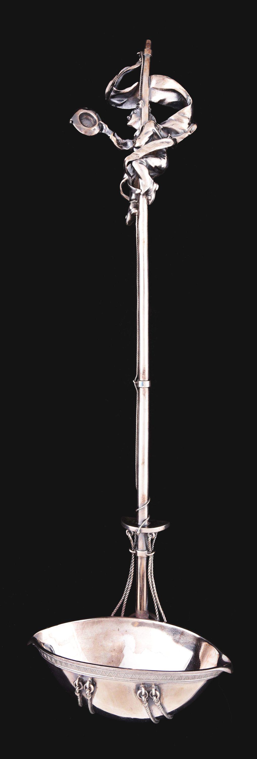 A TIFFANY STERLING FIGURATIVE PUNCH LADLE.: Union Square mark, c.1870, the navette shaped bowl with a chased rim and attached to a mast-like rod stem with cast ropework, the finial cast and chased as a sailor surrounded by a billowing pennant. 