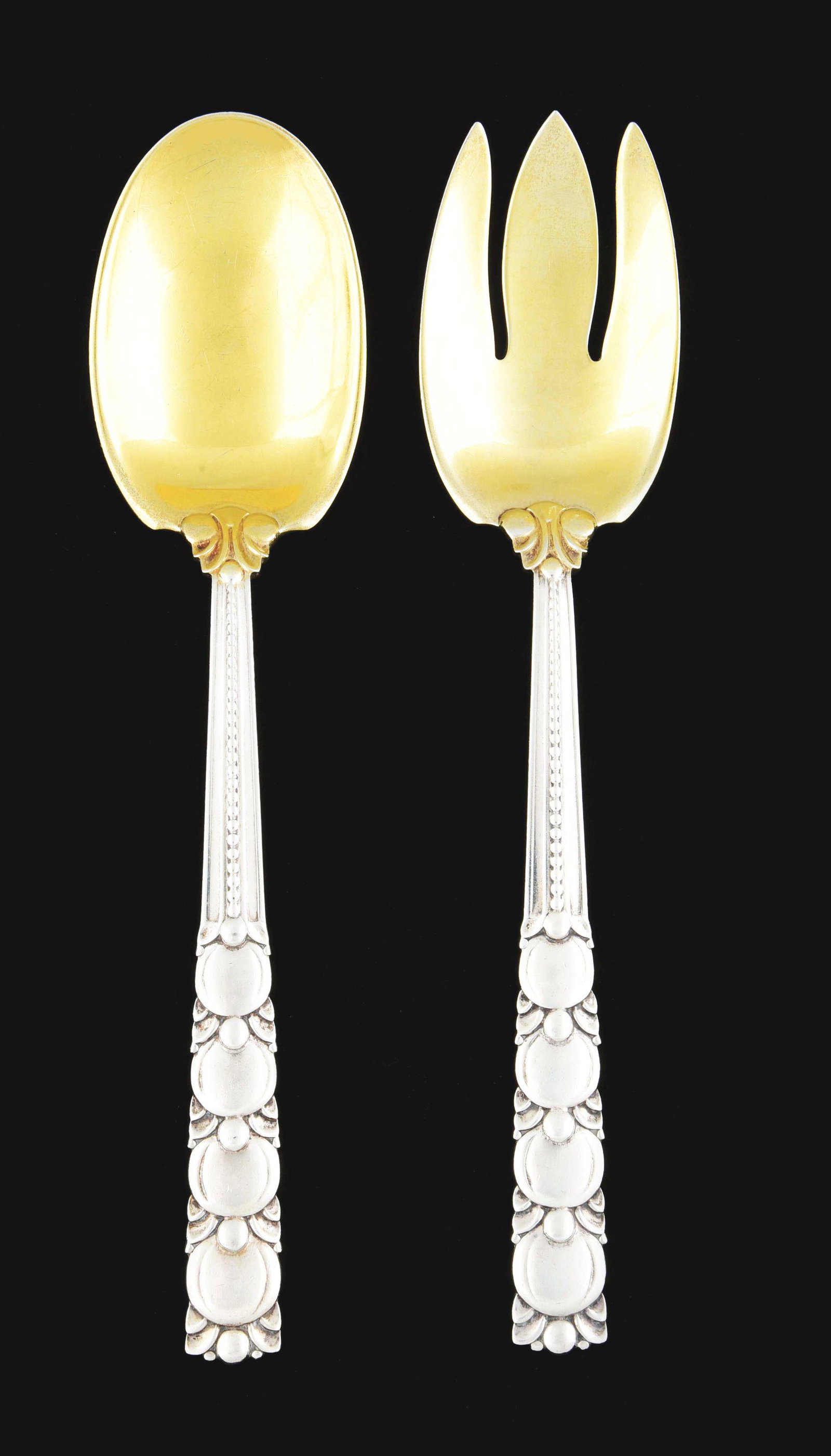 A PAIR OF TIFFANY STERLING SALAD SERVERS.: Tomato pattern, with gilt bowl and tines. No engraving. Length: 9 - 3/4". Weight: 8.5 oz t. Condition: (Excellent). Dimensions: Larger: 9 - 3/4" x 2 - 1/4".