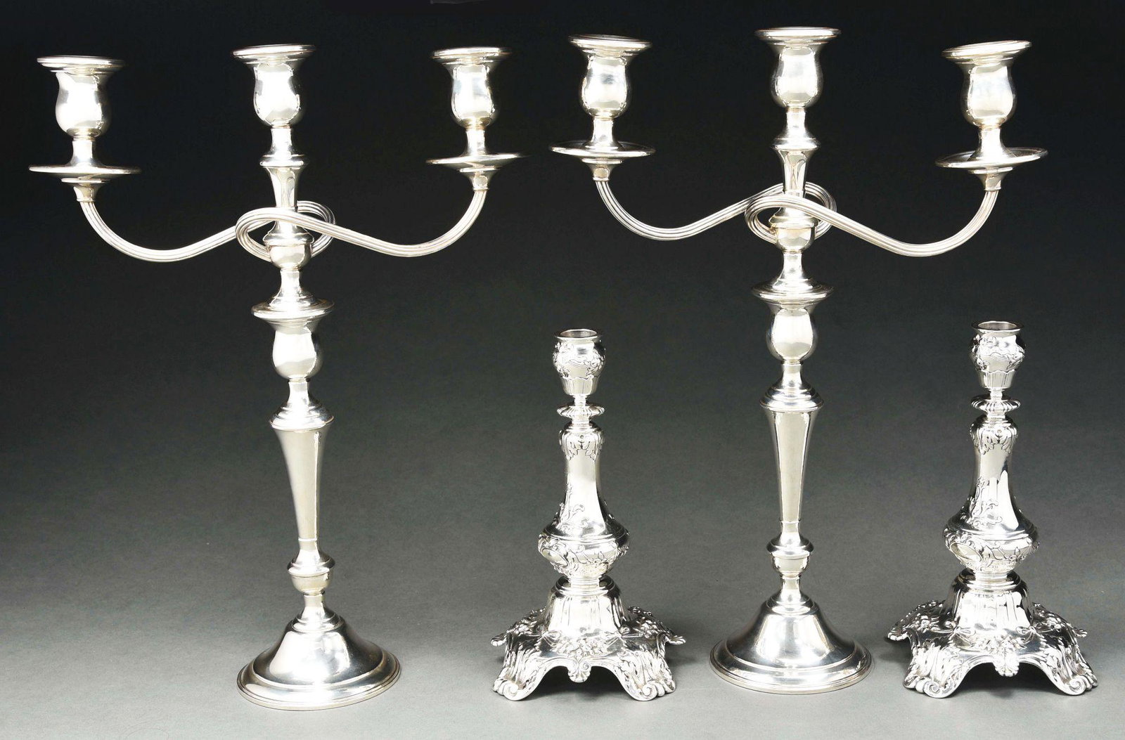 A PAIR OF GORHAM STERLING CANDLESTICKS.: Each with a vase shaped stem and on a broad domed base with four scroll feet, chased and engraved with acanthus leaves and floral motifs, retailed by Spaulding, probably bases for candelabra; and a pa