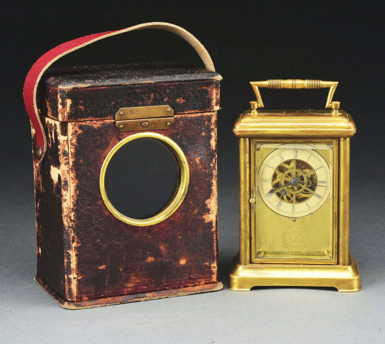 CARRIAGE CLOCK WITH LEATHER STRAP.: Very rare Waterbury Tourbillion. Small carriage clock rarely found with the leather traveling case. Dated on the face 1878. Gilt brass case with paper dial. Leather case in poor condition. Morphy's Au