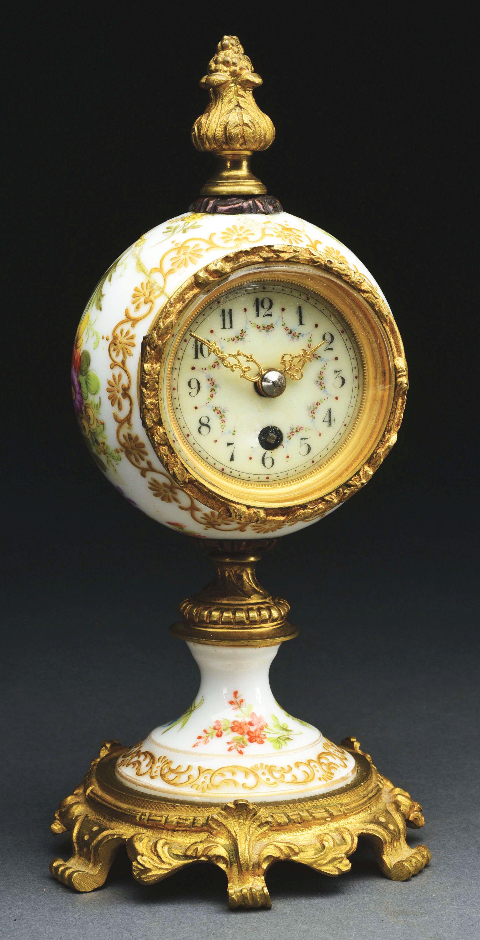 PORCELAIN AND ORMOLU MOUNTED TABLE CLOCK.: Probably French, circa 1880-1890. Polychrome enamel dial. Damage to porcelain and dial. Condition: (Fair). Dimensions: 8 - 1/2" x 4" x 4".