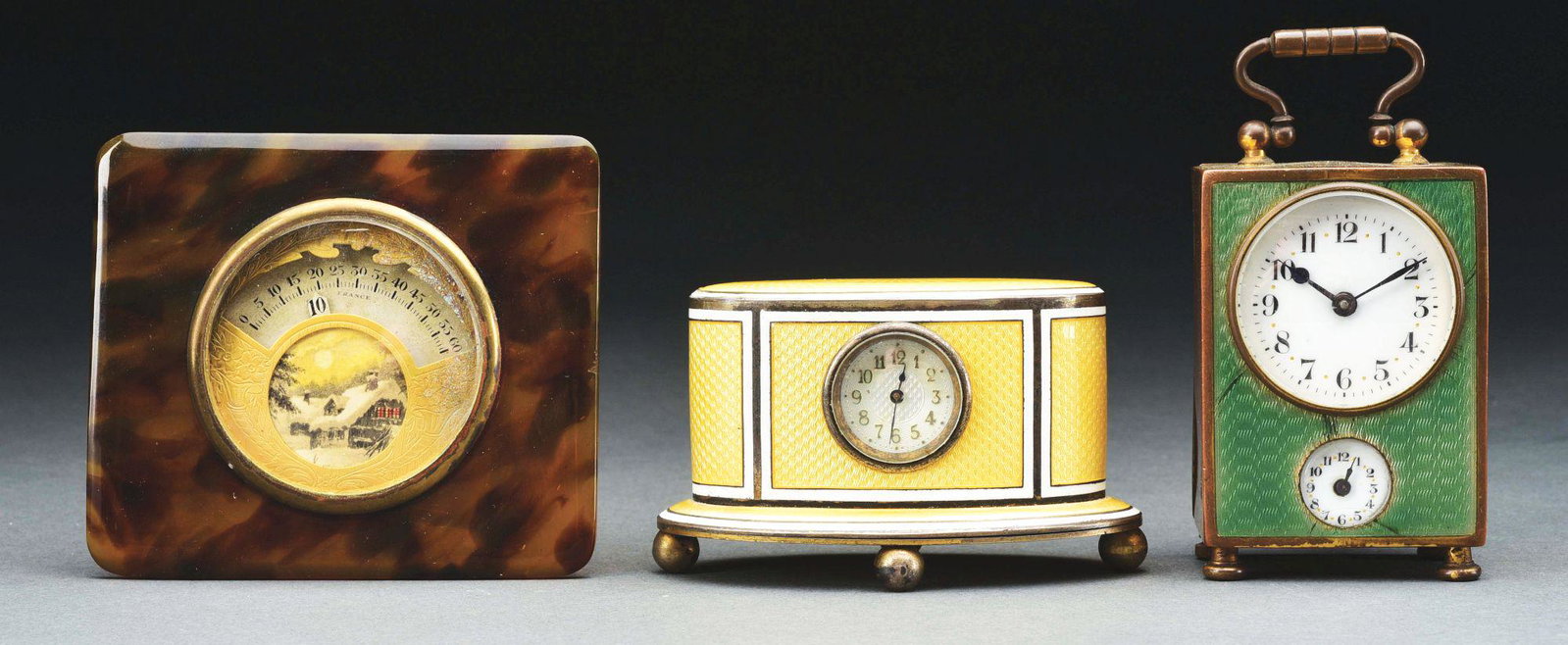 LOT OF 3: SMALL DESK CLOCKS.: 1. Enameled silver desk clock with yellow and white panels. Circa 1920's. 2. Miniature carriage clock with enamel and brass. Double dial with alarm. Circa 1920's. 3. Faux tortoise shell frame with par