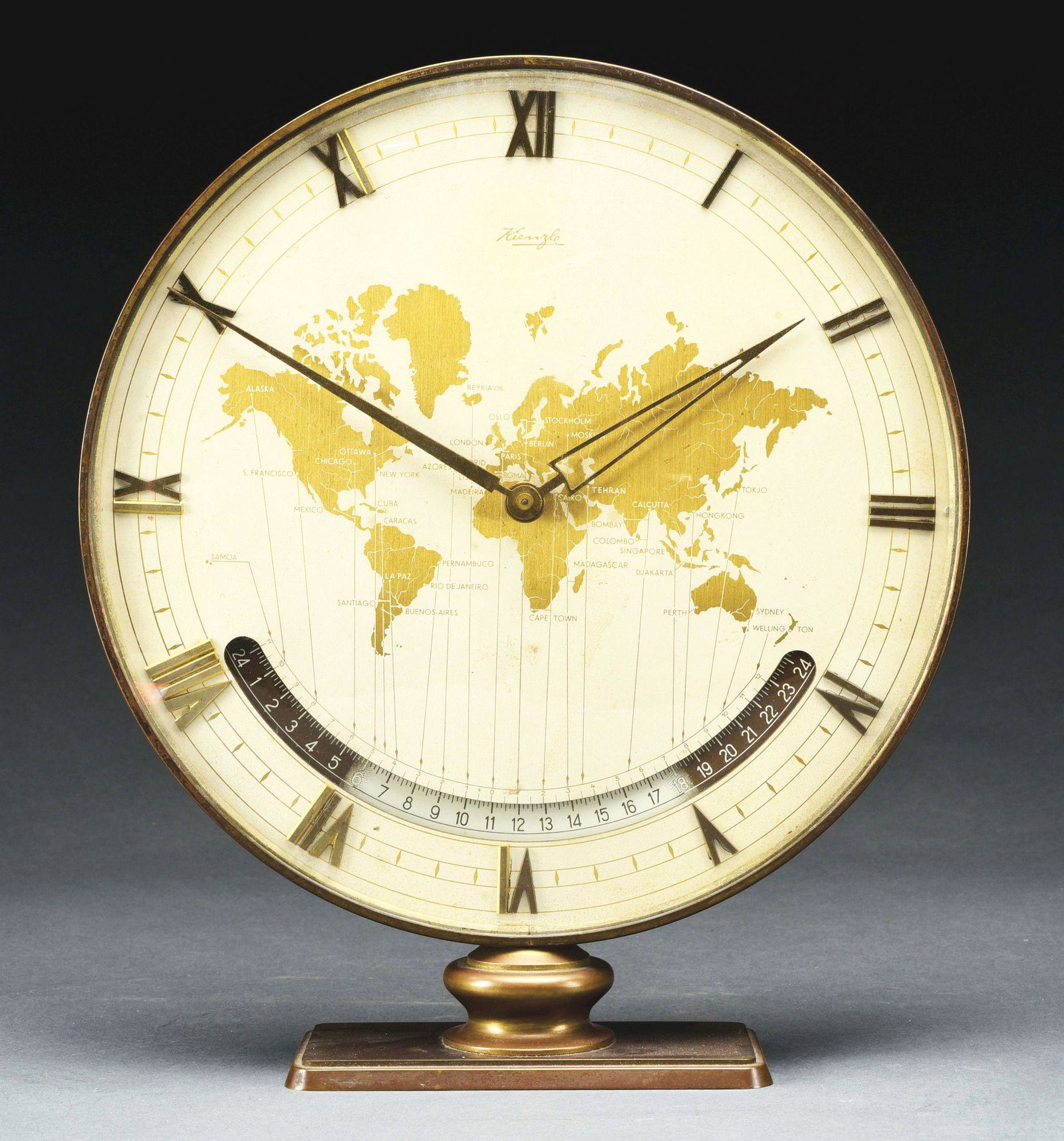 WORLD CLOCK.: By Kienzle. German, circa 1950. Showing times in different parts of the world. Condition: (Good). Dimensions: 11 - 3/4" x 10" x 2 - 3/4".