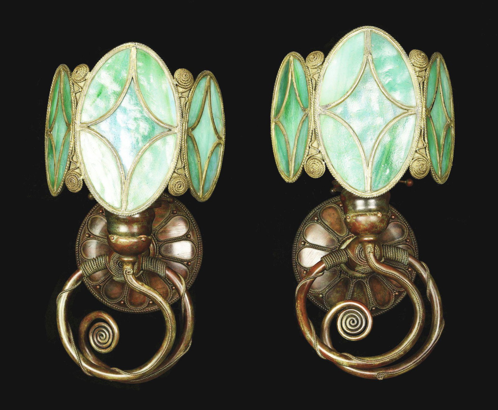 PAIR OF MOORISH SCONCES BY TIFFANY STUDIOS.: A pair patinated bronze and leaded stained glass Moorish Wall Sconces by Tiffany Studios, each decorated with leaded stained glass green tri-panel decorated screen, each set into a decorated Moorish s